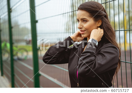 Cheerful longhaired female person preparing for exercises Cheerful longhaired female person preparing for exercises 60715727