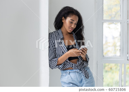 Charming girl in striped shirt having rest at home Charming girl in striped shirt having rest at home 60715806