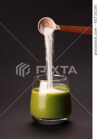 Green juice with spoon of protein 60716295
