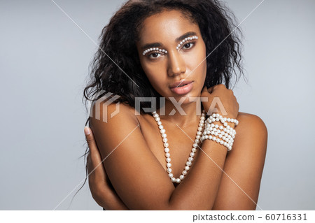 Beautiful woman with startling makeup looking at camera Beautiful woman with startling makeup looking at camera 60716331