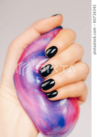 hands with black manicure holding slime hands with black manicure holding slime 60716342