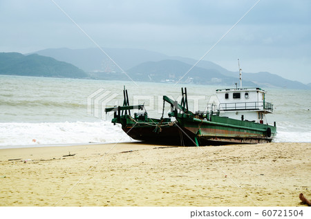 Fishing ship aground on the beach after a storm, Vietnam. 60721504