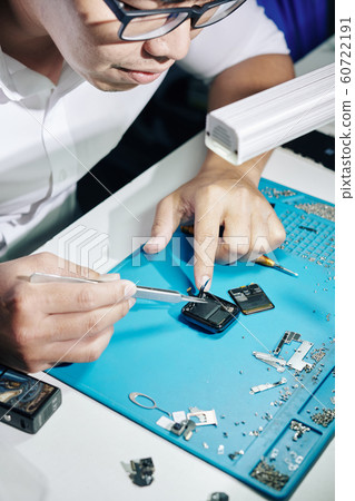 Repairman fixing smartwatch cords Repairman fixing smartwatch cords 60722191