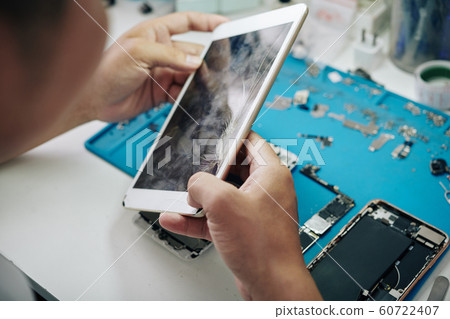 Repairman examining tablet computer 60722407