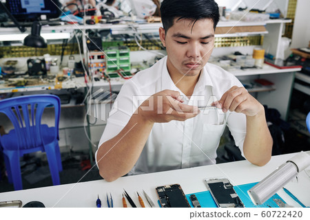Repairman taking photo of smartphone Repairman taking photo of smartphone 60722420