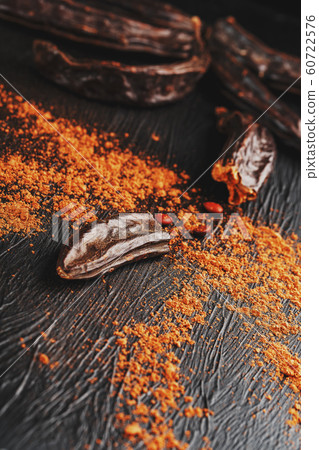 Carob fruit on a black textured background in the 60722576