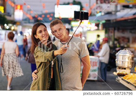 Couple photographing at market Couple photographing at market 60726796