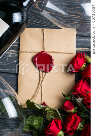 Red rose flowers around envelope with wax seal Red rose flowers around envelope with wax seal 60729584