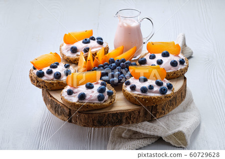 Buns with soft cheese, blueberry and persimmon 60729628