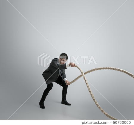 Caucasian man in office clothes training isolated on grey studio background 60730000