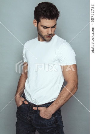 Muscle strong face beautiful stripped male model portrait in denim blue jeans white t-shirt on grey isolated font background with shadow Muscle strong face beautiful stripped male model portrait in denim blue jeans white t-shirt on grey isolated font background with shadow 60732788