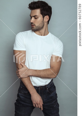 Muscle strong face beautiful stripped male model portrait in denim blue jeans white t-shirt on grey isolated font background with shadow 60732789