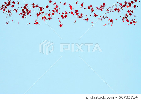 Frame from red stars glitter confetti on blue background. Festive backdrop. 60733714