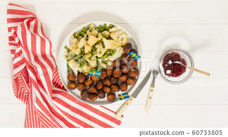 Traditional swedish meatballs (kottbullar) with cauliflower and green peas, brown sauce in the white plate. Swedish flags. Swedish national food concept. Background photo. Traditional swedish meatballs (kottbullar) with cauliflower and green peas, brown sauce in the white plate. Swedish flags. Swedish national food concept. Background photo. 60733805