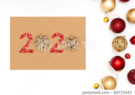 2020 made of red sparkles and decorative christmas toys on craft sheet of paper. 60733843