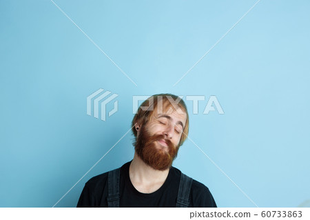 Portrait of young caucasian man looks dreamful and happy Portrait of young caucasian man looks dreamful and happy 60733863