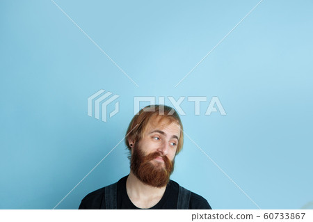 Portrait of young caucasian man looks dreamful and happy Portrait of young caucasian man looks dreamful and happy 60733867