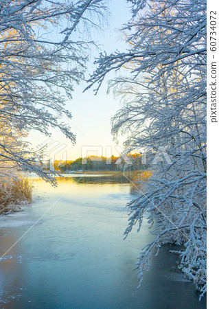 Frozen stream (canal) and trees with snow. Winter in scandinavia. Swedish landscape wallpaper. Frozen stream (canal) and trees with snow. Winter in scandinavia. Swedish landscape wallpaper. 60734072