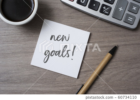 text new goals in a note on a desk 60734110