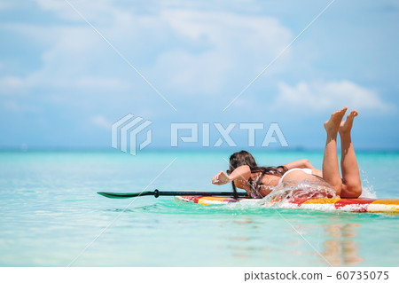Active young woman on stand up paddle board Active young woman on stand up paddle board 60735075