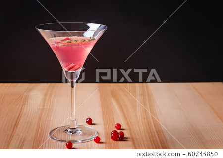 Red color cocktail with cranberry in martini glass on the wooden table 60735850