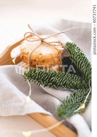 Composition of fresh cookies and spruce branches on a wooden tray. 60737741