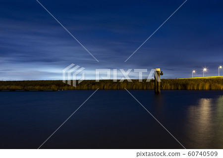 Bright skylight behind a dyke in a harbour in Bruinisse. 60740509