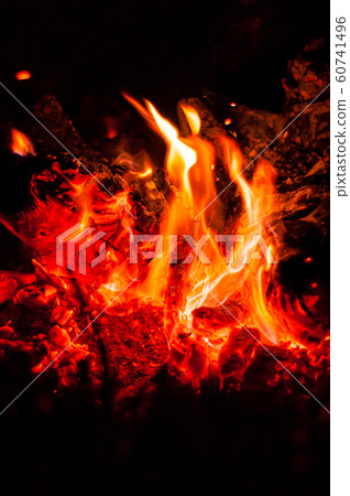 Heat from bright flame of dying bonfire. Close-up. 60741496