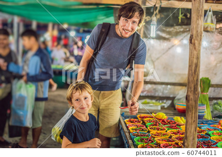 Dad and son are tourists on Walking street Asian food market 60744011