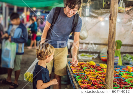 Dad and son are tourists on Walking street Asian food market 60744012