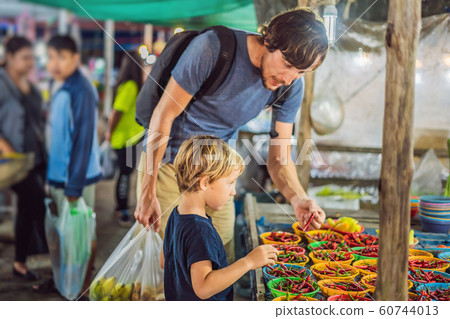 Dad and son are tourists on Walking street Asian food market 60744013