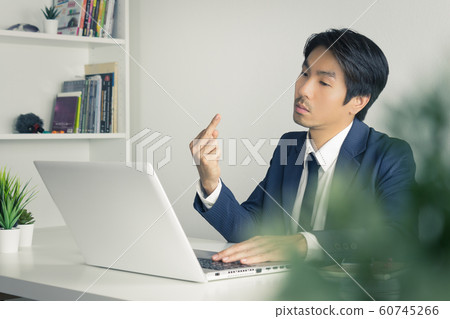 Angry Asian Businessman Show Middle Finger in front of Laptop in Vintage Tone Angry Asian Businessman Show Middle Finger in front of Laptop in Vintage Tone 60745266