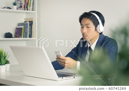 Asian Man Call Center Send Message to Customer by Smartphone with Tree Foreground in Vintage Tone 60745269
