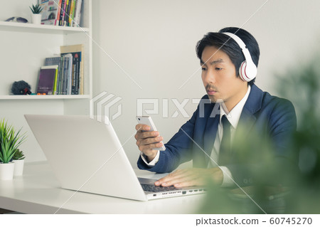 Asian Man Call Center Contact with Customer by Smartphone and Laptop in Vintage Tone Asian Man Call Center Contact with Customer by Smartphone and Laptop in Vintage Tone 60745270