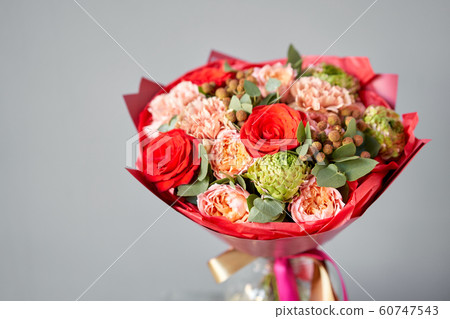 European floral shop. Beautiful bouquet of mixed flowers in glas vase. the work of the florist at a flower shop. Delivery fresh cut flower. European floral shop. Beautiful bouquet of mixed flowers in glas vase. the work of the florist at a flower shop. Delivery fresh cut flower. 60747543