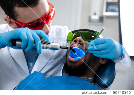 Young african-american man visiting dentist's office 60748540