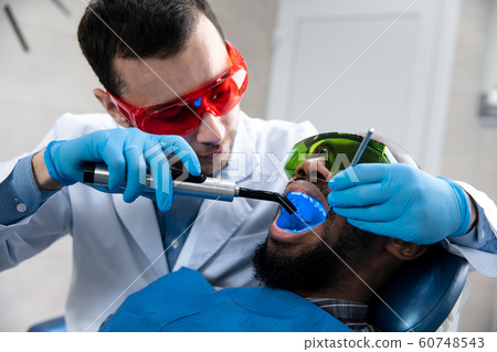 Young african-american man visiting dentist's office 60748543