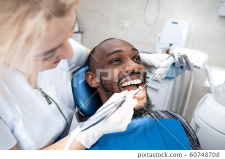 Young african-american man visiting dentist's office, smiling Young african-american man visiting dentist's office, smiling 60748708