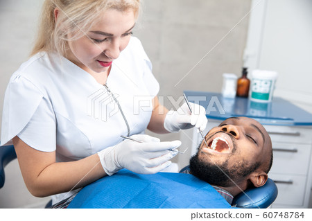 Young african-american man visiting dentist's office 60748784