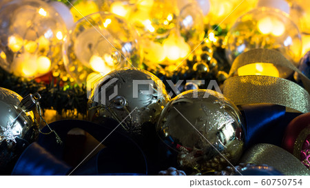 Christmas and new year tree toys with beautiful ribbons on the background of garlands and illuminations. The new year 2020. Christmas and new year tree toys with beautiful ribbons on the background of garlands and illuminations. The new year 2020. 60750754