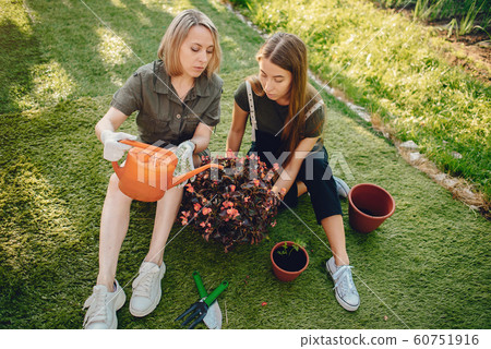 Mother with a daughter works in a garden near the house Mother with a daughter works in a garden near the house 60751916
