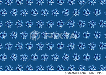 Christmas pink background with circle frame of blue bows. 60751956