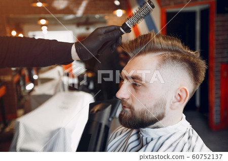 Stylish man sitting in a barbershop Stylish man sitting in a barbershop 60752137