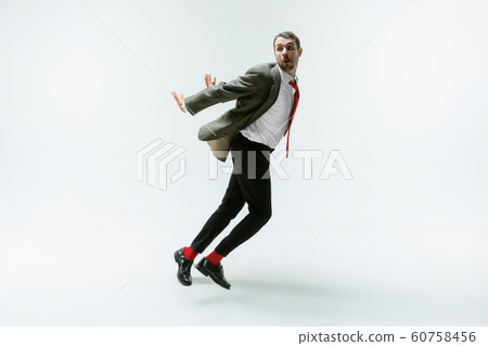 Young caucasian man moving flexible on white studio background Young caucasian man moving flexible on white studio background 60758456