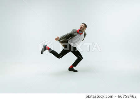 Young caucasian man moving flexible on white studio background Young caucasian man moving flexible on white studio background 60758462