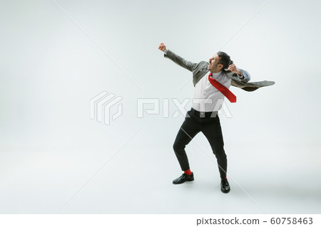 Young caucasian man moving flexible on white studio background 60758463