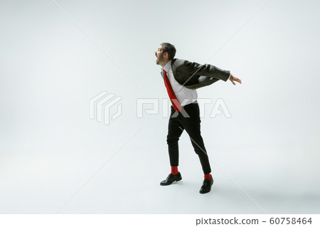 Young caucasian man moving flexible on white studio background Young caucasian man moving flexible on white studio background 60758464