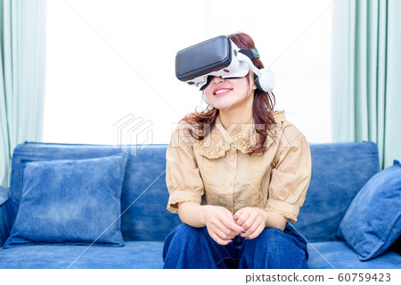 Woman watching VR on sofa Woman watching VR on sofa 60759423