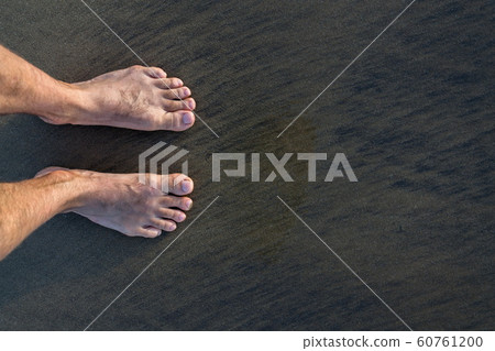 Human barefoot feet in wet sand on sea shore, active healthy living and personal growth concept, copy space Human barefoot feet in wet sand on sea shore, active healthy living and personal growth concept, copy space 60761200