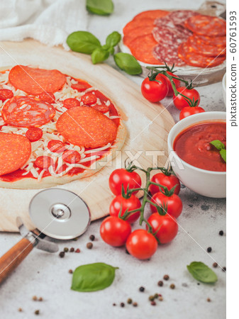 Preparation for baking of pepperoni pizza with Preparation for baking of pepperoni pizza with 60761593